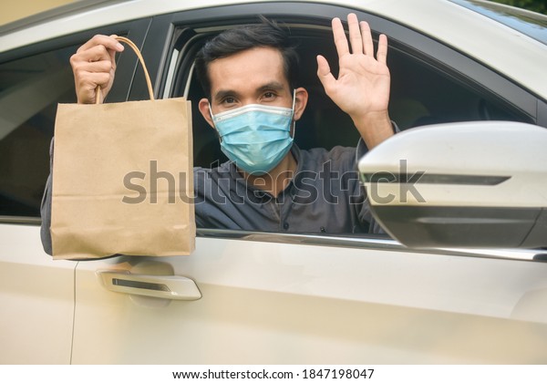 Asian man wear face mask holding\
shopping bag sitting in car,Mask protect coronavirus covid\
19