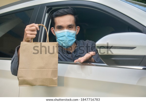 Asian man wear face mask holding
shopping bag sitting in car,Mask protect coronavirus covid
19