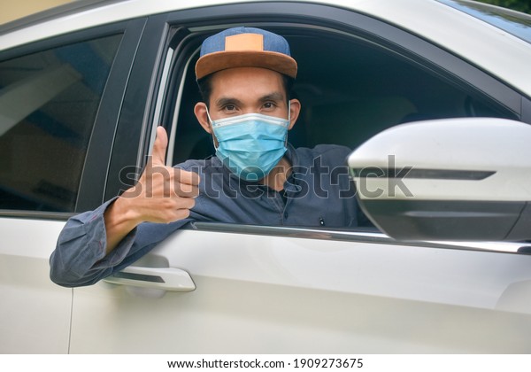 Asian man wear medical mask sitting\
in car to protect coronavirus covid19 ,Mask prevent\
PM2.5
