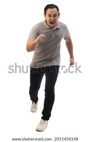 Asian man wearing grey shirt black denim and white shoes, screaming while running toward camera, front view. Full body portrait isolated cut out