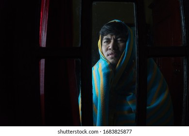 Asian Man wearing mask and Blanket feeling sick Covid-19 Praya,West Nusa Tenggara/ Indonesia - March 26 2020