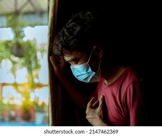 An Asian man wearing a mask has difficulty breathing and has a side effect after suffering from COVID-19. - Shutterstock ID 2147462369