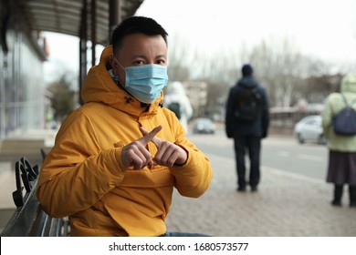 Hombre asiático con máscara médica en la calle de la ciudad, espacio para texto. Brote de virus