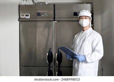 Asian man wearing sanitary clothes inspecting the kitchen - Powered by Shutterstock