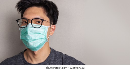 Asian Man Wearing White Face Mask And Eye Glasses Close Up