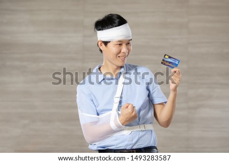 Asian man wears blue shirt with credit card  concept is We can use credit card for medical treatments in case of accidents.