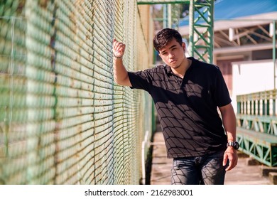 Asian Man Who Coaches A Sports Team Stand On The Sidelines Or Tennis Chords.