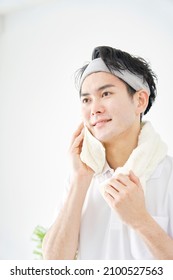 Asian Man Wiping His Face With A Towel