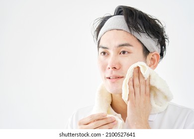 Asian Man Wiping His Face With A Towel