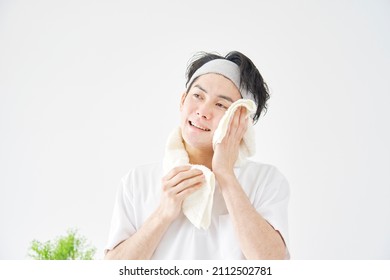 Asian Man Wiping His Face With A Towel