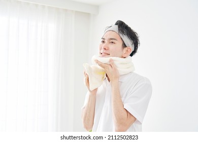 Asian Man Wiping His Face With A Towel