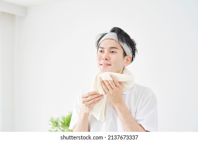 Asian Man Wiping His Face With A Towel