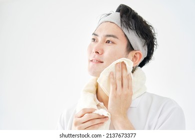 Asian Man Wiping His Face With A Towel