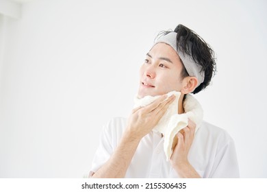 Asian Man Wiping His Face With A Towel