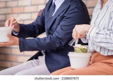 Asian Man And Woman Eating Takeout Salad