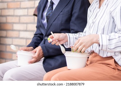 Asian Man And Woman Eating Takeout Salad