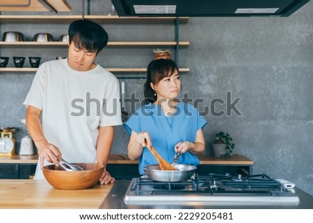 Asian man and woman fighting while cooking
