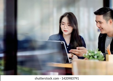 Asian Man And Woman Freelance Team Working On A Project With Laptop In Co Working Space