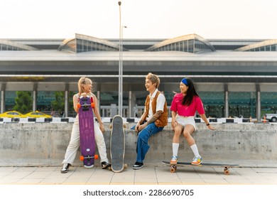 Asian man and woman friends resting together after skating on longboard skate at public park. Stylish youth people enjoy urban outdoor lifestyle outdoor extreme sports skateboarding on summer vacation - Powered by Shutterstock