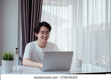 Asian man working from home with laptop computer self isolation from society to reduce risk, quarantine prevention coronavirus, covid-19 and study e-learing online education technology concept.
