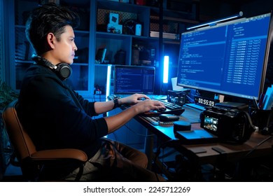 Asian man working and looking at the Computer Monitor in the Dark Office. He pays attention to the screen and works very hard in and very serious mood.
wood desk. hand on the keyboard.

 - Shutterstock ID 2245712269