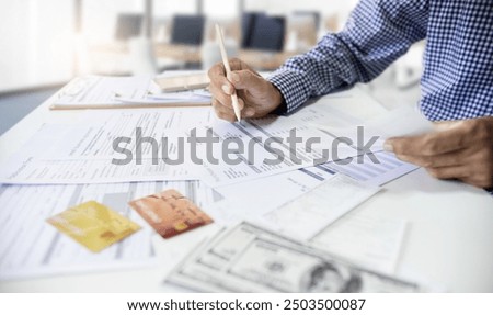 Asian man working in office checking purchase order and financial bills. calculate expenses and business cost to be pay after use credit card 
