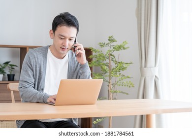 Asian man working on a computer at home