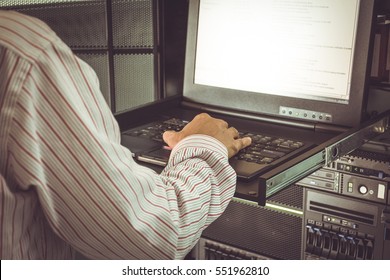 Asian Man Working On His Computer Server Mainframe In A Data Center , Process In Vintage Style