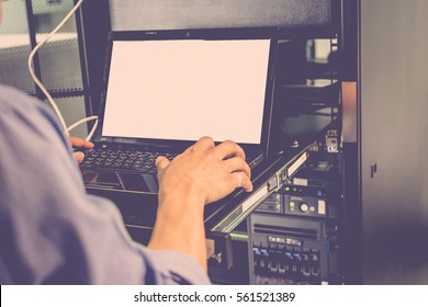 Asian Man Working On His Computer Server Mainframe In A Data Center , Process In Vintage Style