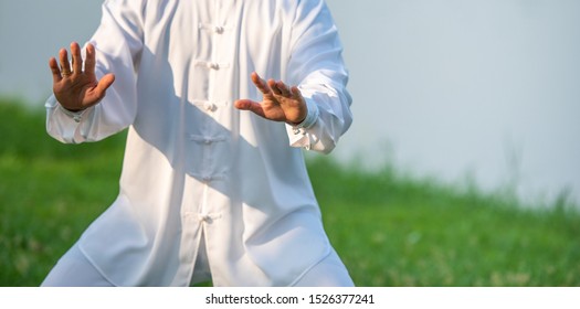 Asian man working out with Tai Chi in the morning at the park, Chinese martial arts, healthy care for life concept. - Shutterstock ID 1526377241