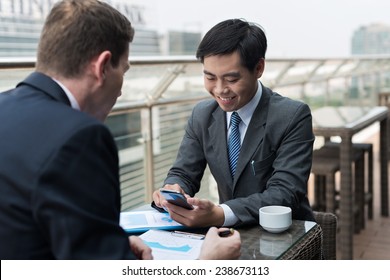 Asian Manager Using Smartphone During Business Meeting