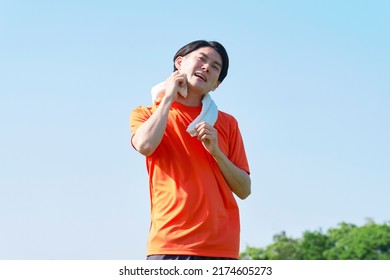 Asian Manan Wiping Sweat During Exercise