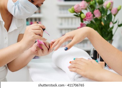 Asian Manicurist Carefully Applying Pink Nail Polish