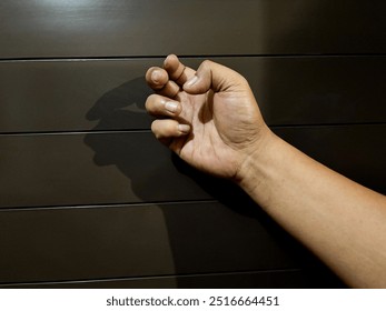 An Asian man's hand knocks on the door - Powered by Shutterstock