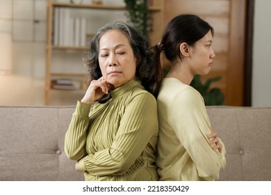 Asian mature mom and adult daughter have fight at home while sitting on sofa. - Shutterstock ID 2218350429