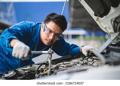 Asian Mechanic In A Car Repair Shop. Mechanic In Service Center Car Safety Check. Repair Service Concept. Professional Service Concept