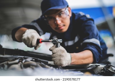 Asian Mechanic In A Car Repair Shop. Mechanic In Service Center Car Safety Check Repair Service Concept. Professional Service Concept