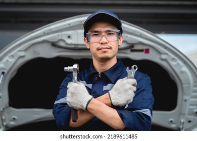 Asian Mechanic With Repair Equipment Standing Confidently In A Car Repair Shop. Auto Mechanic In The Service Center. Car Safety Inspection. Repair Service Concept.