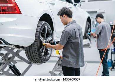 Asian Mechanics Checking The Car Wheels At Maintainance Service Center For In Showroom