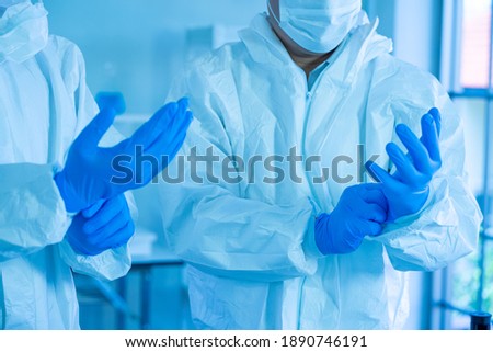 Asian medical doctors wearing PPE protective suit working in Laboratory for virus vaccine.