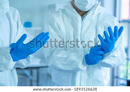 Asian medical doctors wearing PPE protective suit working in Laboratory for virus vaccine.