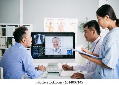 Asian Medical Interns Consullting With Doctor Online