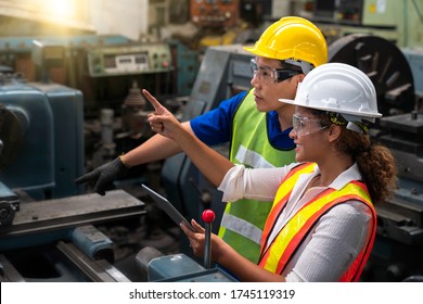 Asian Men And African American Women Are Working In Industrial Plants. Hold The Tablet In Your Hand To See How The Machine Works.