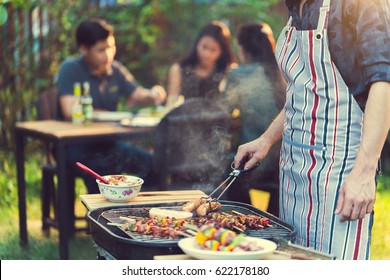 Asian men are cooking for a group of friends to eat barbecue - Shutterstock ID 622178180