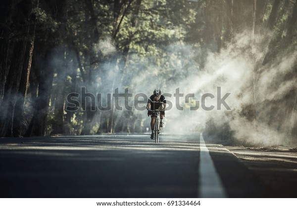 Asian men are\
cycling road bike in the\
morning