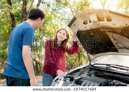 Asian men explaining about the engine in the car. Let Asian women listen She was very satisfied and grateful to him.