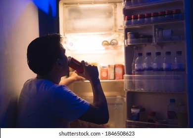  Asian Men He Is Opening The Refrigerator.Drink Soft Drinks At Night