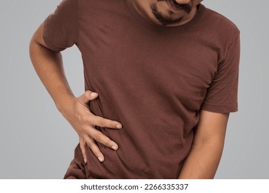 Asian men ribcage pain on gray background.