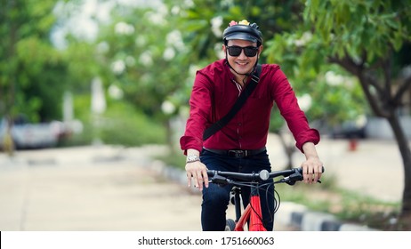 Asian Men Ride Bicycles To Work. Take The Park Path