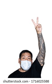 Asian men is wear a medical mask and showing a hand with victory sign in white background with copy space above.The concept of protest, attention, request. Place for text or copy space. Clipping path.